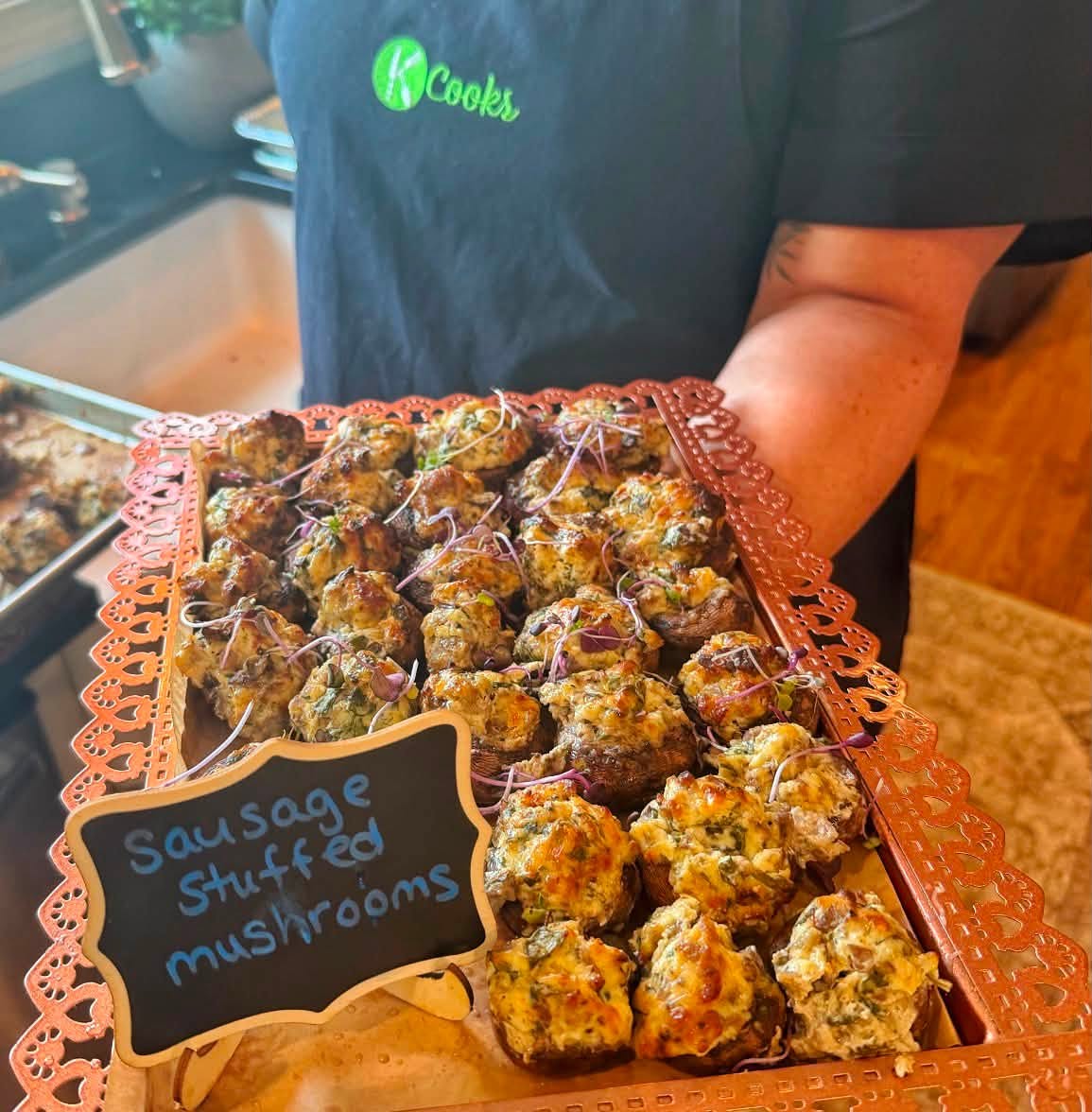 Tray of K Cooks sausage stuffed mushrooms with a chalkboard label